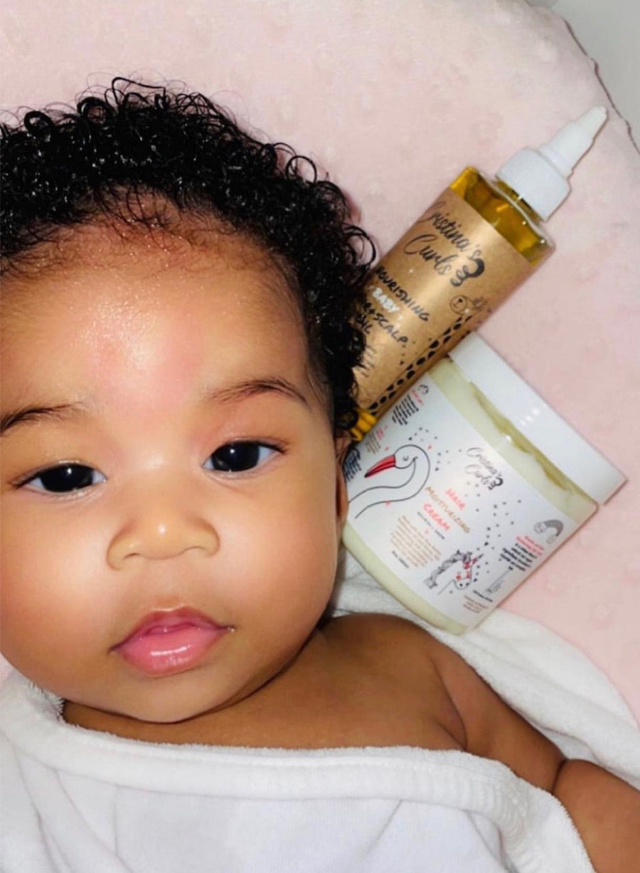 A parent combing conditioner through a child's coily hair