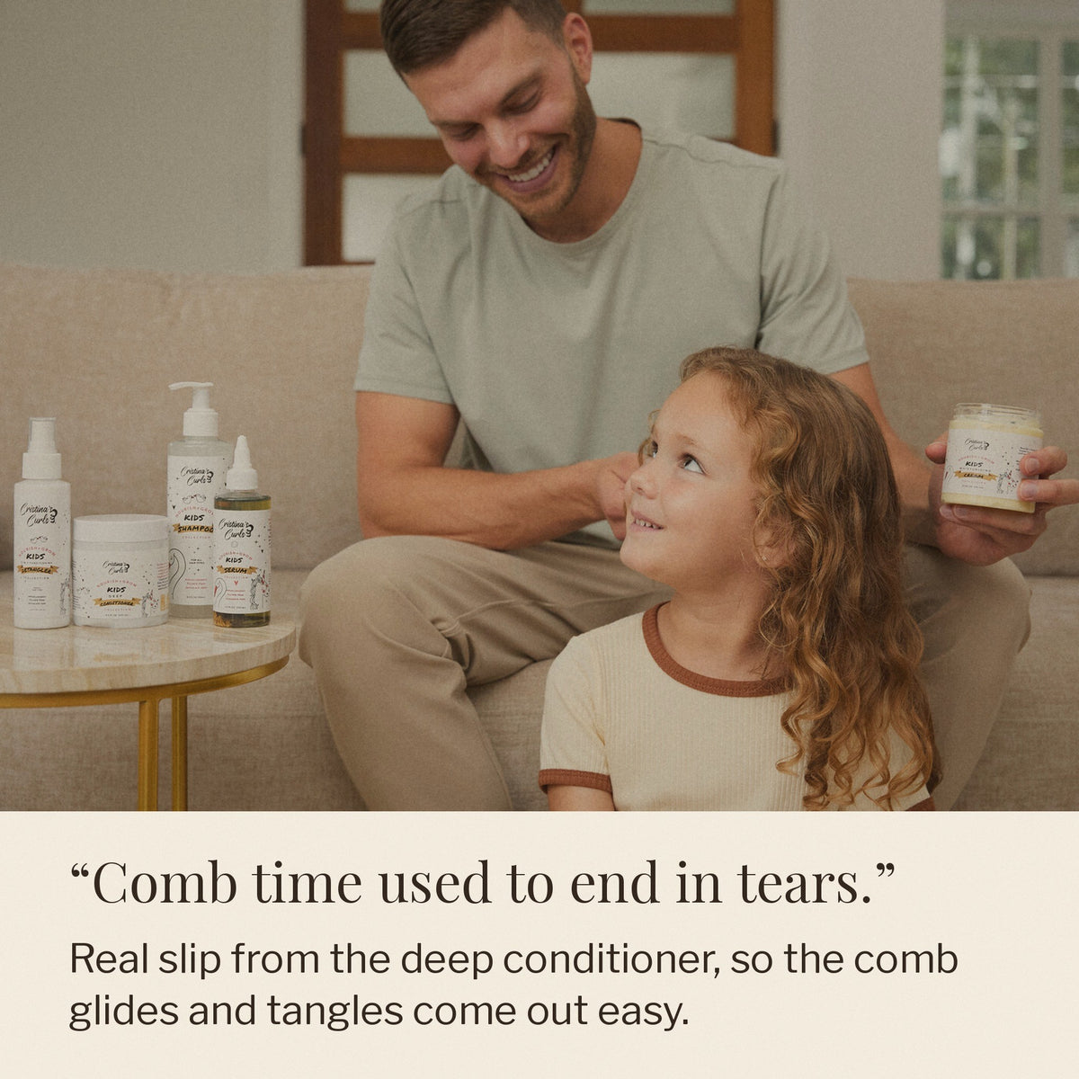 Dad combing his daughter's curls with Nourish + Grow bottles on the table beside them