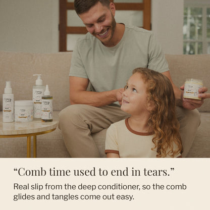 Dad combing his daughter's curls with Nourish + Grow bottles on the table beside them