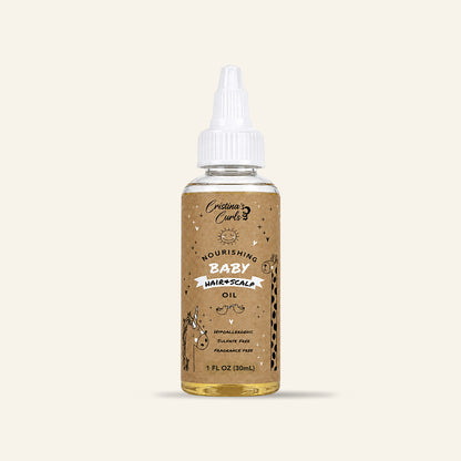 Nourishing Baby Hair and Scalp Oil travel size (1 oz) on a cream background