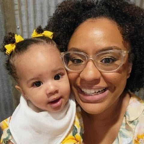 A smiling mom cheek to cheek with her daughter